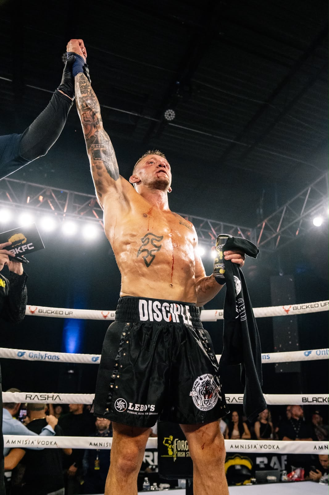 Dustin Pague having his hand raised in victory