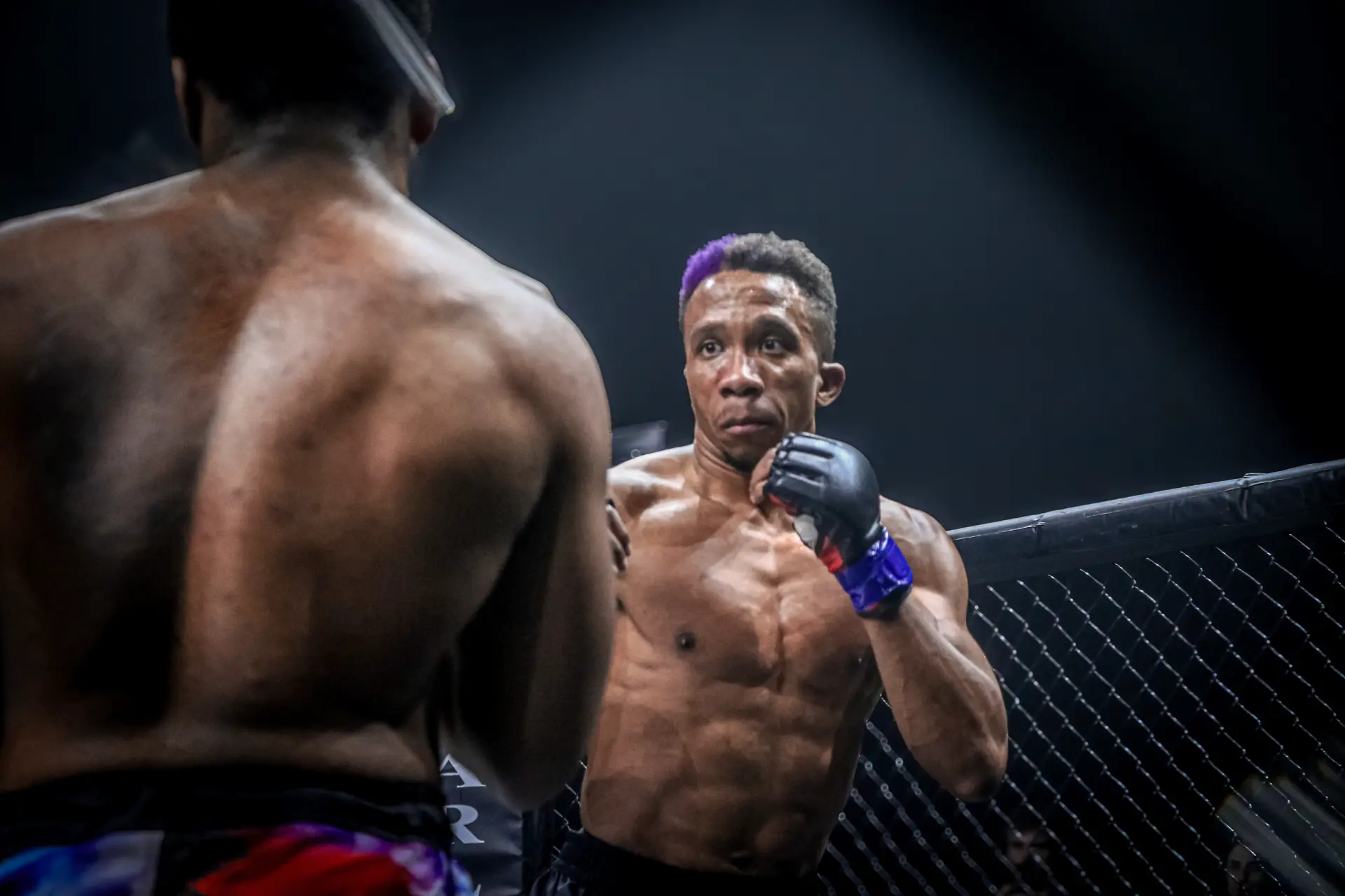 George Watkins facing off with his opponent across the cage