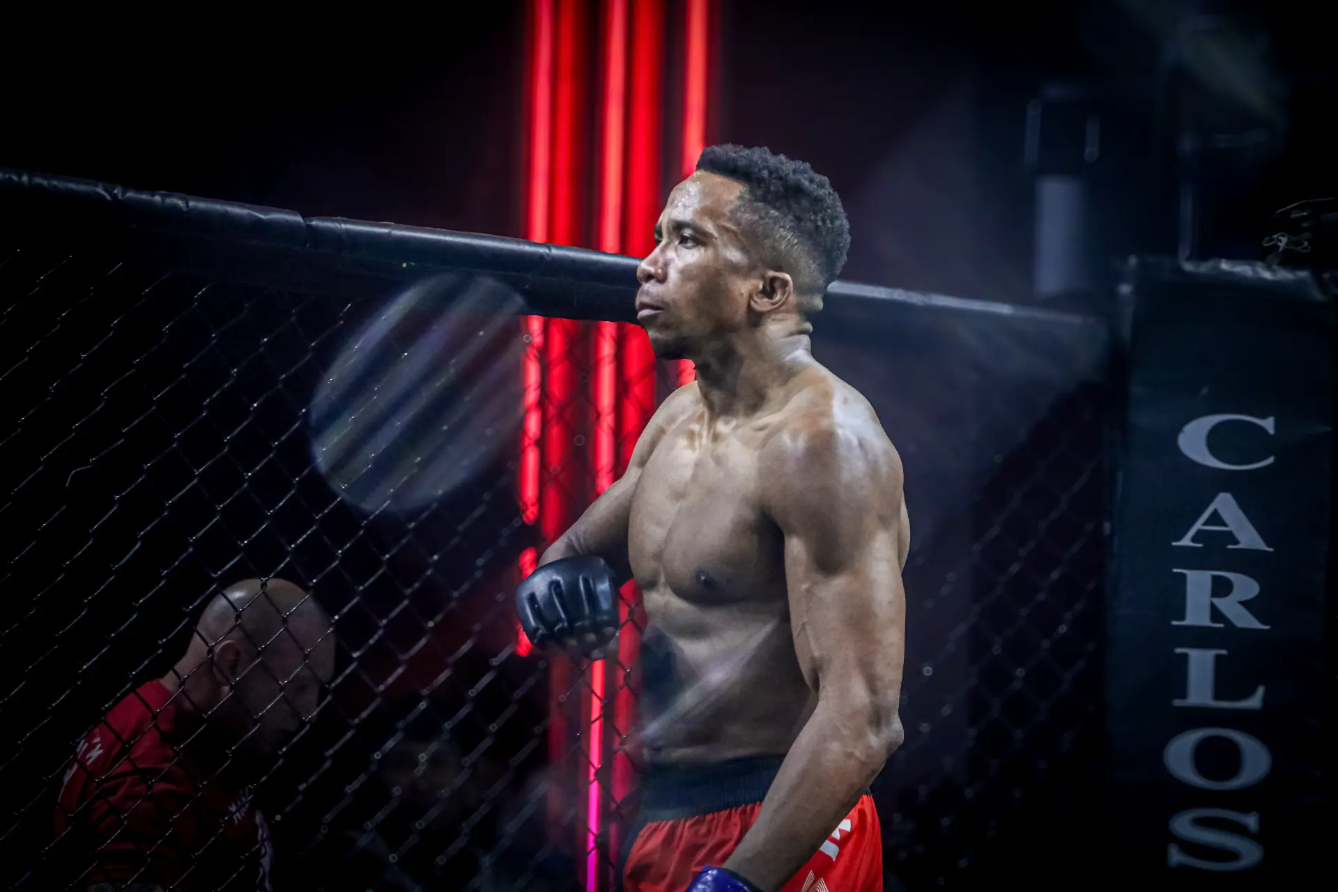 George Watkins leaning against the cage during a fight
