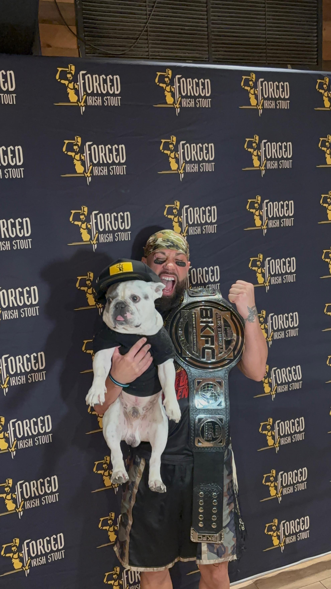 Quentin "QG" Gaskins holding his French bulldog and the BKFC championship belt