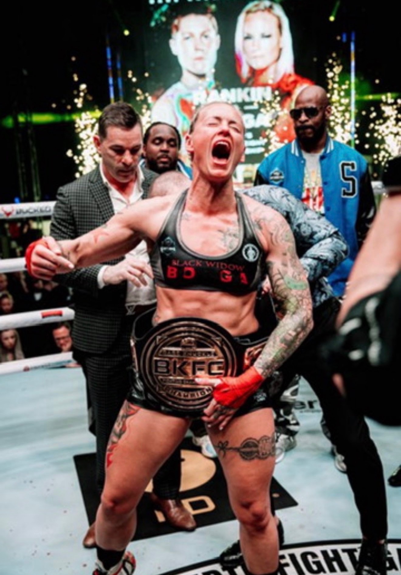 Jessica Borga celebrating in the ring with the BKFC championship belt around her waist