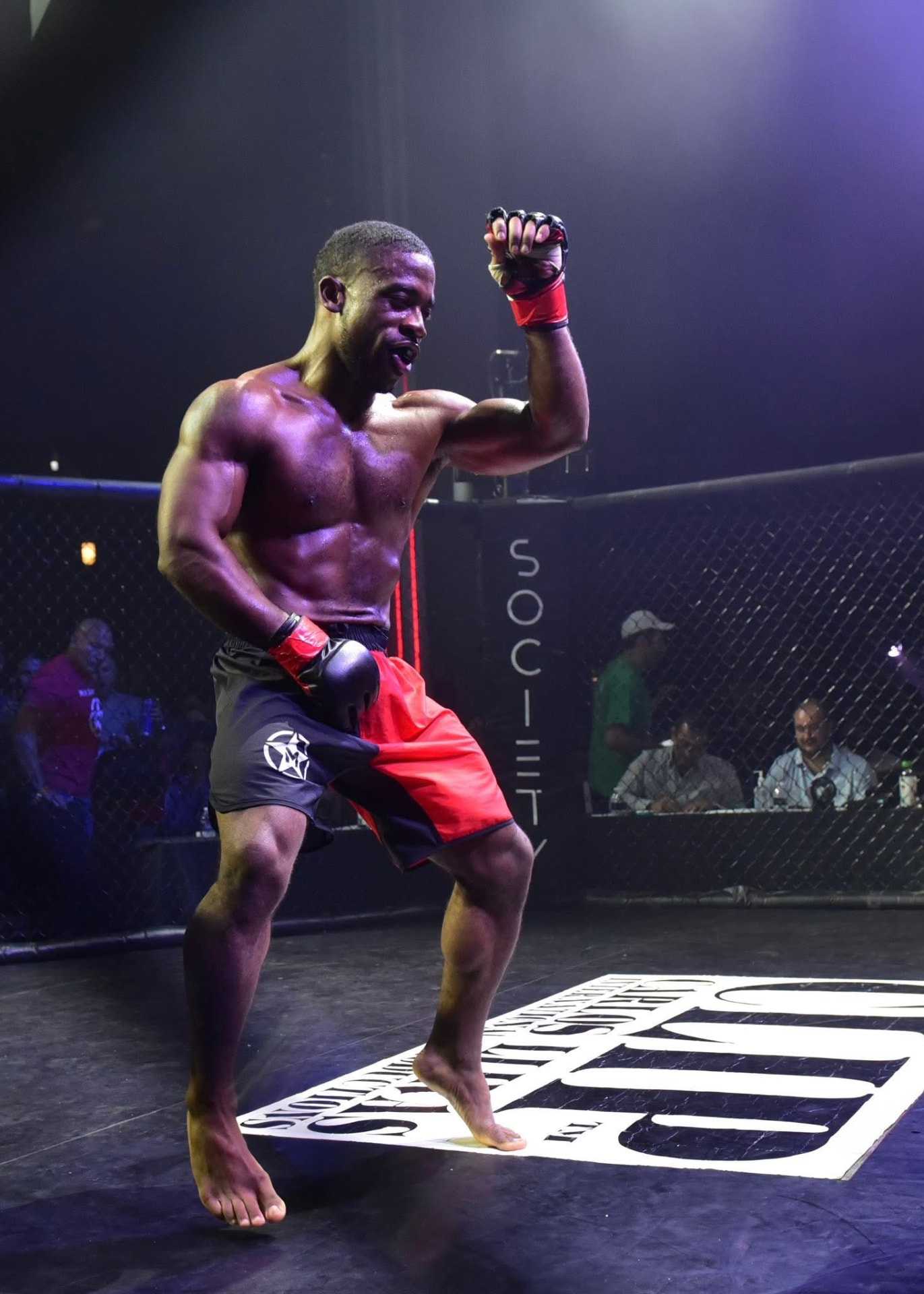 Devin Thomas flexing after a victory in the cage