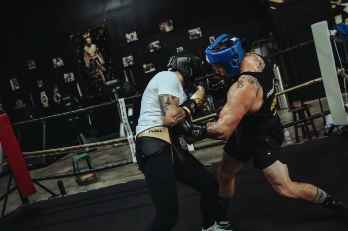 Dave Mundell sparring in blue headgear inside a dark gym ring