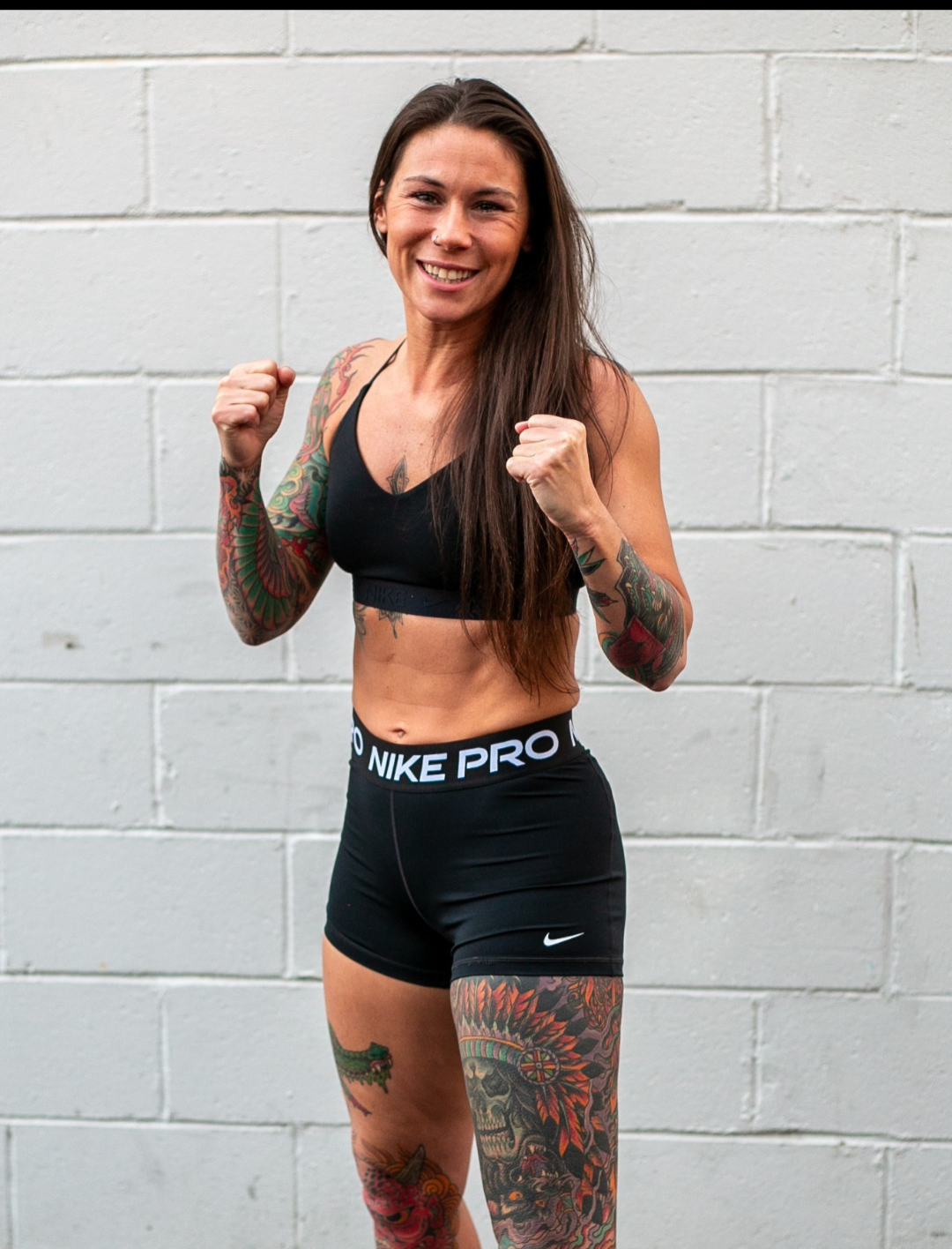 Brooke Evans smiling with fists up outside the gym