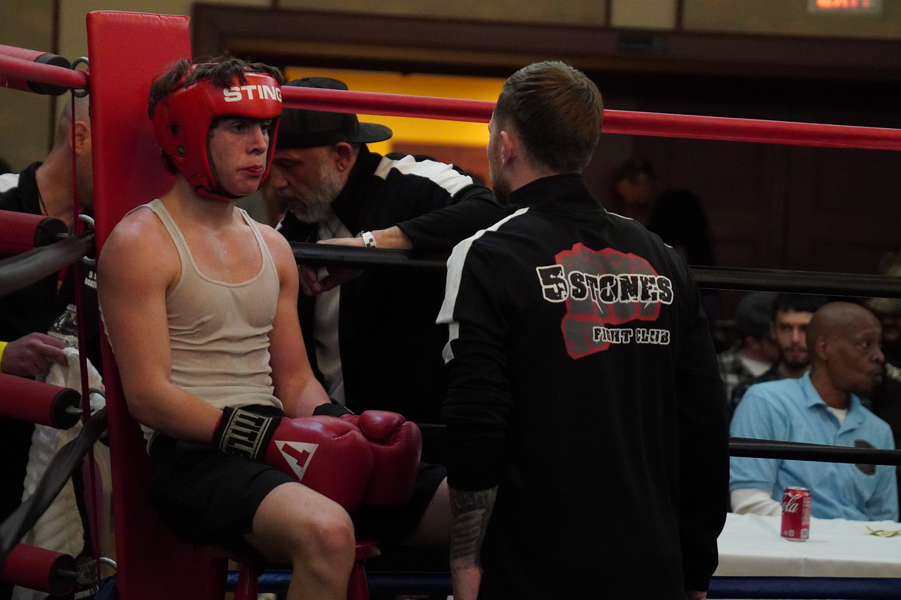 Andrew Waybright in headgear listening to his corner between rounds